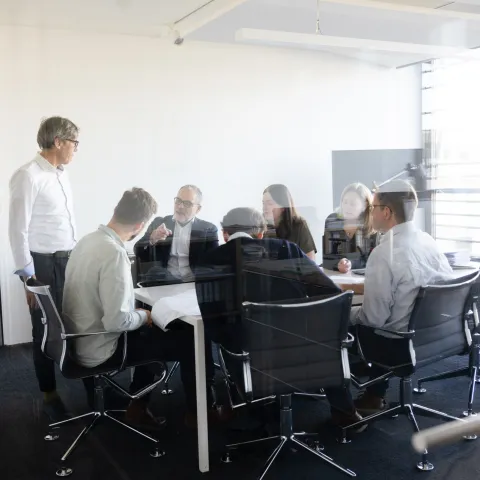 Man sieht ein Team von sieben GAPP Mitarbeitern/Mitarbeiterinnen während einer Besprechung.