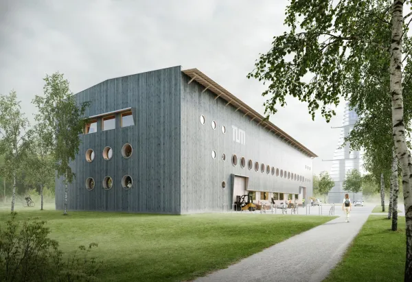 TUMorrow Factory Außenansicht: längliches Holzgebäude mit runden Fenstern im Grünen gelegen.