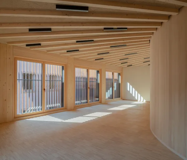 Gruppenraum in der Kinderoase. Das Bild zeigt einen lichtdurchfluteten Raum komplett in Holz verkleidet.