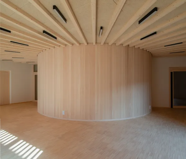 Gruppenraum in der Kinderoase. Das Bild zeigt einen lichtdurchfluteten Raum komplett in Holz verkleidet.