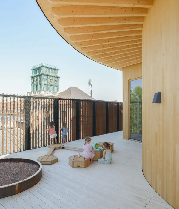 Spielende Kinder auf der Himmelswiese (Dachterrasse) mit dem Uhrenturm im Hintergrund.